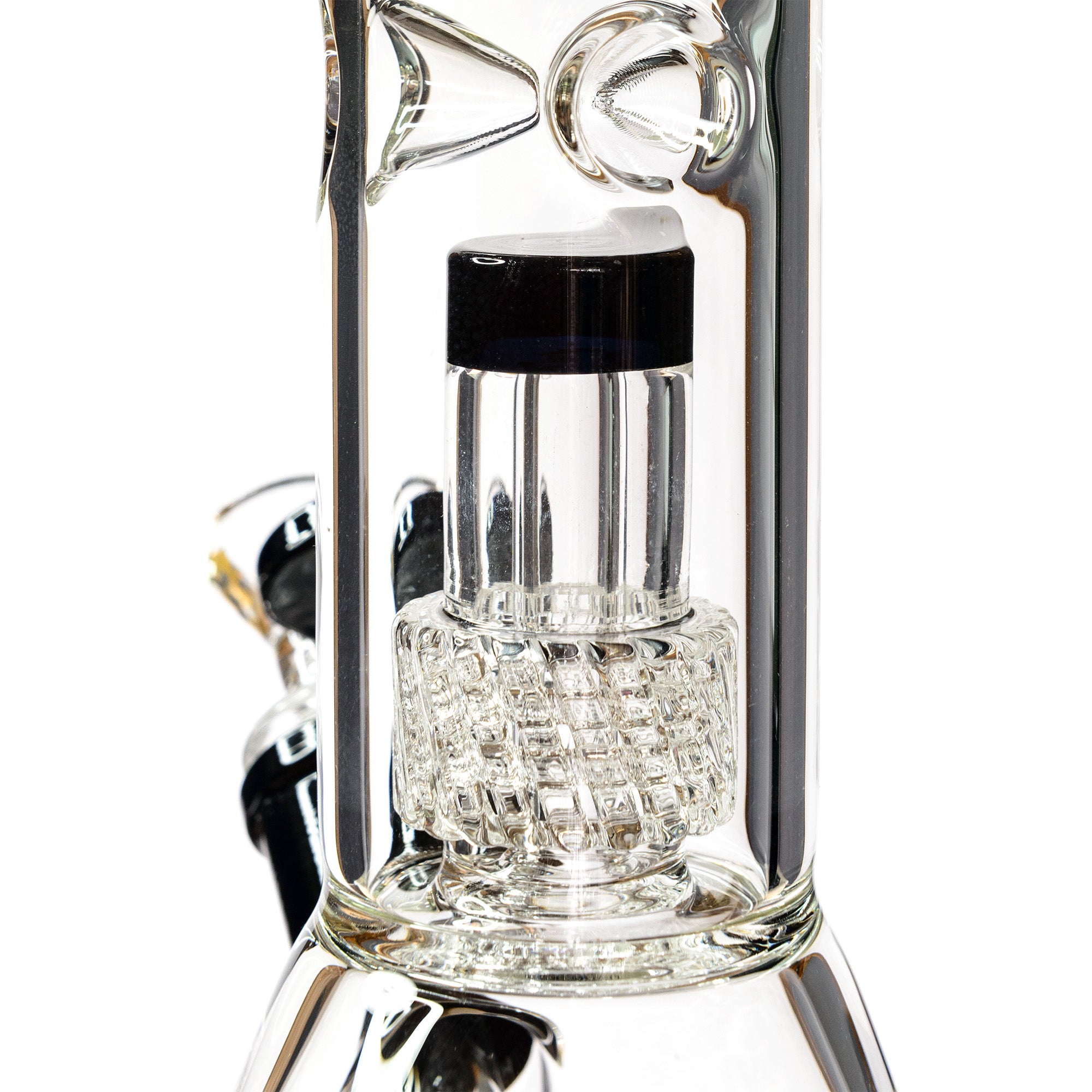 Macro detail view of the precision cut glass matrix percolator and black glass cap inside the straight chamber.
